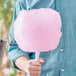 A man holding a large pink cotton candy.