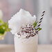 A glass of milkshake made with Great Western Mint Green Cotton Candy and topped with whipped cream.