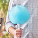 A person holding a blue cotton candy made with Great Western Blue Raspberry Cotton Candy Sugar.
