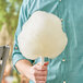 A person holding a large cotton candy made with Great Western Pina Colada Cotton Candy Sugar.