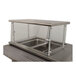 An Advance Tabco cafeteria food shield with a stainless steel shelf over a counter.