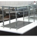 A stainless steel and glass self service food shield on a bakery counter.