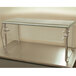 An Advance Tabco single tier self-service food shield with a glass top and metal legs.