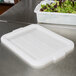 A white Vollrath plastic lid on a white Vollrath plastic food storage box with green and red lettuce inside.
