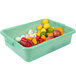 A green Vollrath Traex Color-Mate perforated drain box full of various fruits and vegetables.