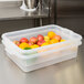 A Vollrath Color-Mate clear plastic container filled with fruit.