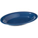 A white table with a blue oval deep platter filled with food.