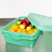 A Vollrath green food storage container with oranges inside.