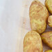 A close-up of a group of potatoes in a clear Vollrath perforated drain box.