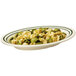 An oval platter of tortellini with green and white stripes.