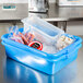A Vollrath blue plastic container with ice and food in it.