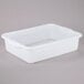 A white rectangular Vollrath Color-Mate bus tub with handles.