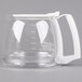 A clear glass coffee carafe with a white handle.