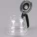 A clear glass coffee pot with a black handle.