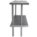 An Advance Tabco stainless steel double deck overshelf on a table with metal legs.