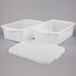 A group of three white plastic containers with lids.