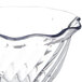 A Carlisle clear polycarbonate tulip berry dish with a wavy edge.