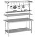 A stainless steel Advance Tabco middle mount pot rack with pots over a work table.
