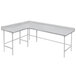 A white Advance Tabco L-shaped corner work table with metal legs.