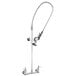 A silver T&S EasyInstall wall mounted pre-rinse faucet with a hose.