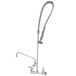 A T&S stainless steel wall mounted pre-rinse faucet with hose.