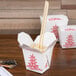 A white Fold-Pak Chinese takeout box with chopsticks inside.