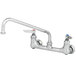 A chrome T&S wall mount pantry faucet with two lever handles and a swing nozzle.