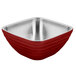 A red and silver Vollrath square beehive serving bowl on a counter.