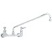 A chrome T&S wall mounted pantry faucet with two long handles and a hose.