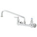 A T&S chrome wall mounted pantry faucet with two handles and a hose.