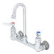 A chrome T&S wall mount faucet with lever handles.