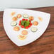 An American Metalcraft white triangular concave melamine platter with food on it.