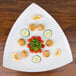 An American Metalcraft white triangular melamine platter with food on it.