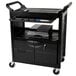 A black Rubbermaid utility cart with lockable doors and a sliding drawer on a counter.