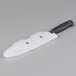 A white knife with a black Victorinox plastic blade cover.
