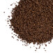 A pile of dark roast coffee powder on a white background.