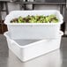 A white Tablecraft plastic freezer safe drain box filled with green and red lettuce.