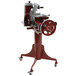 A red and silver Berkel 330M Prosciutto Slicer stand with a wheel.