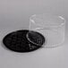 A black plastic D&W Fine Pack cake display container with a clear dome lid.