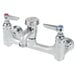 A silver T&S wall mount mop sink faucet with two knobs.
