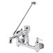 A T&S polished chrome wall mount service sink faucet with handles and a hose.