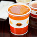A close-up of a Choice paper soup cup with a vented plastic lid.