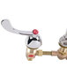 A chrome T&S deck mount faucet with brass and red accents.