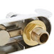 The brass wrist action handles and gooseneck spout of a T&S deck-mount faucet.