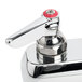 A chrome T&S deck-mount faucet with red handles and a 6" swing nozzle.