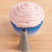 A cupcake with pink frosting piped on top using an Ateco 843 Closed Star Piping Tip.