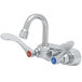 A T&S chrome wall mount faucet with 4" wrist action handles.