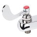 A chrome T&S deck-mount faucet with a red handle and knob.
