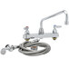 A chrome T&S deck-mount workboard faucet with a hose and spray nozzle.