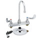 A T&S deck-mount faucet with gooseneck spout, wrist action handles, and sidespray.